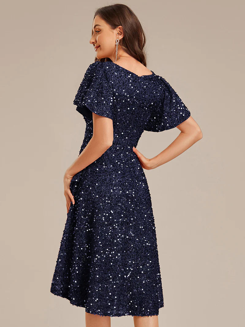 Elegant sequin high-low formal navy blue dress featuring short ruffle sleeves and a deep V-neckline – ideal for weddings, galas, or prom nights.