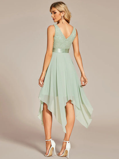 Woman wearing a mint green dress with a high-low hem on a beige background