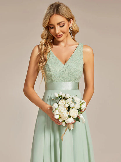 Woman in a lmint green dress holding a bouquet of flowers against a beige background