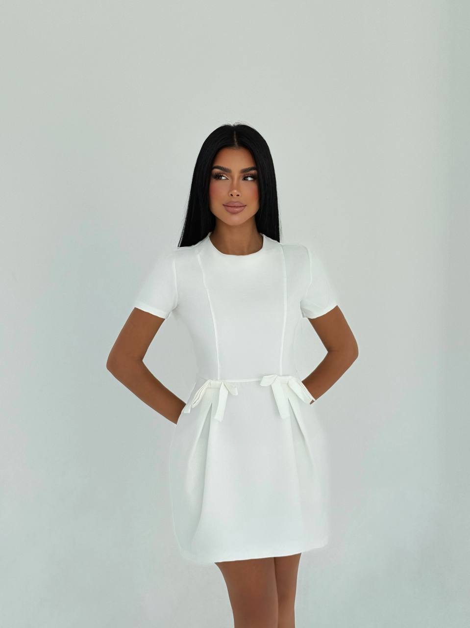 Simple and elegant white mini dress with waist bow details for a casual look