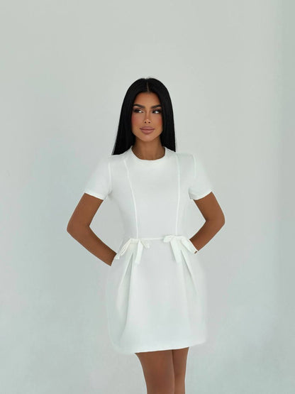 Simple and elegant white mini dress with waist bow details for a casual look