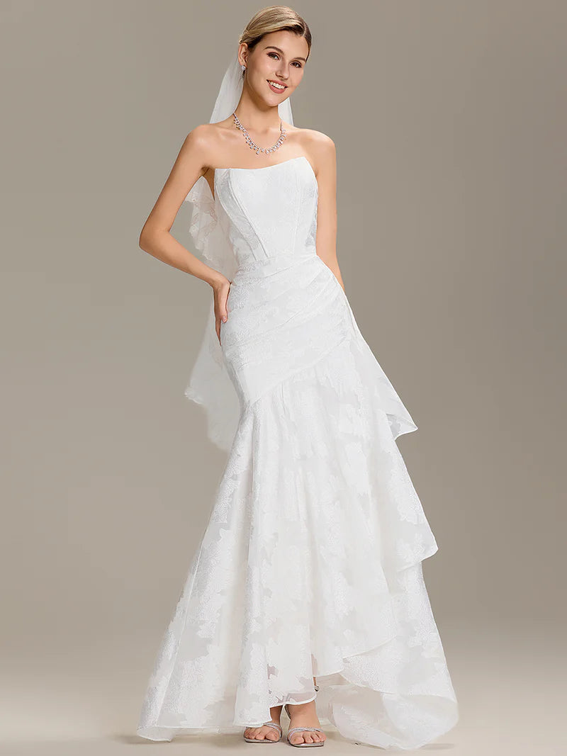 White jacquard wedding dress with strapless bodice, cold shoulder sleeves, and fishtail silhouette